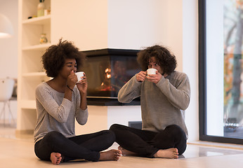 Image showing multiethnic couple  in front of fireplace