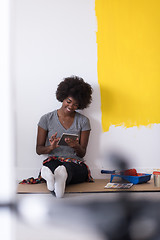 Image showing back female painter sitting on floor