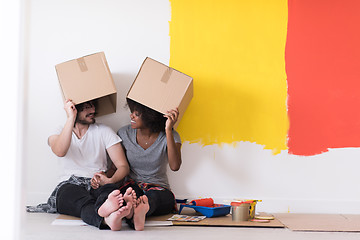 Image showing young multiethnic couple playing with cardboard boxes