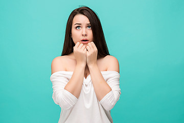 Image showing Frustrated young woman posing on blue