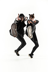 Image showing The silhouettes of two hip hop male and female break dancers dancing on white background