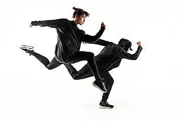 Image showing The silhouettes of two hip hop male and female break dancers dancing on white background