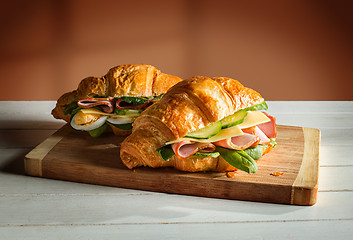 Image showing Croissants sandwiches on the wooden cutting board