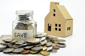 Image showing Coins in jar with paper house