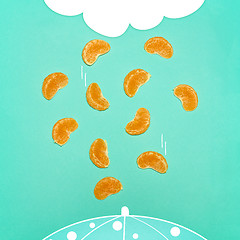 Image showing The pop art collage of fresh Tangerine wedges and abstract drawing rain cloud and raindrops falling