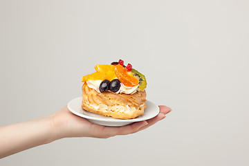 Image showing Closeup of cake with fresh fruits on gray background.