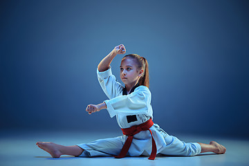 Image showing Young girl training karate on blue background