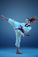 Image showing Young girl training karate on blue background