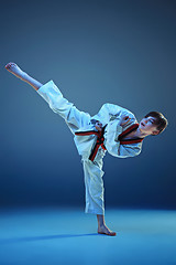 Image showing Young boy training karate on blue background