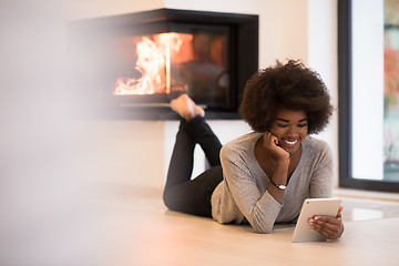 Image showing black women using tablet computer on the floor