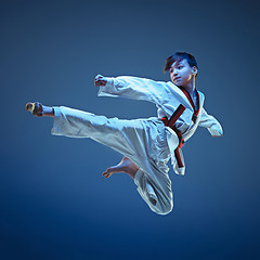 Image showing Young boy training karate on blue background