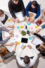 Image showing Team sitting behind desk, checking reports, talking. Top View