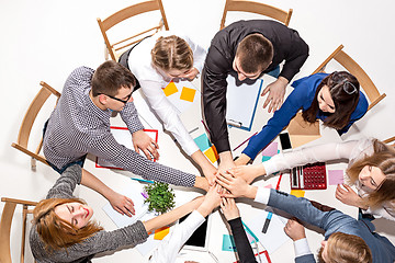 Image showing Team sitting behind desk, checking reports, talking. Top View