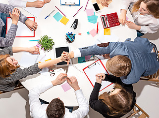 Image showing Team sitting behind desk, checking reports, talking. Top View