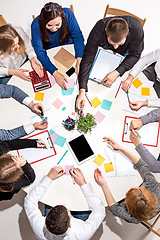 Image showing Team sitting behind desk, checking reports, talking. Top View