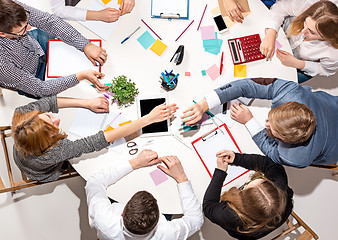 Image showing Team sitting behind desk, checking reports, talking. Top View