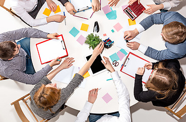 Image showing Team sitting behind desk, checking reports, talking. Top View