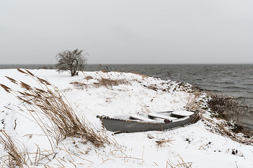 Image showing Old rowing boat at a snowy coast