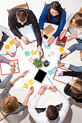 Image showing Team sitting behind desk, checking reports, talking. Top View