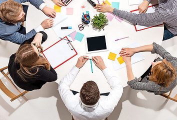 Image showing Team sitting behind desk, checking reports, talking. Top View