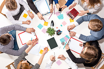 Image showing Team sitting behind desk, checking reports, talking. Top View