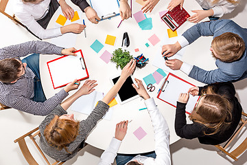 Image showing Team sitting behind desk, checking reports, talking. Top View