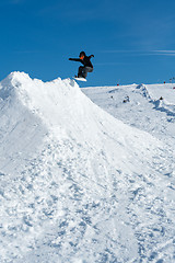 Image showing Snowboarder jumping against blue sky