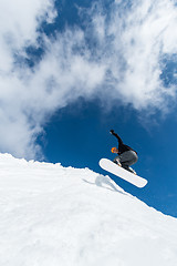 Image showing Snowboarder jumping against blue sky