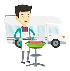 Image showing Man having barbecue in front of camper van.