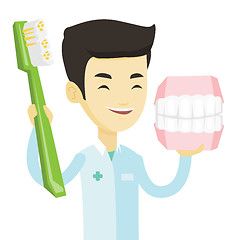 Image showing Dentist with dental jaw model and toothbrush.