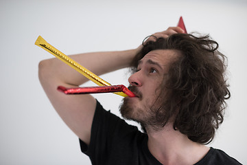 Image showing Portrait of a man in party hat blowing in whistle