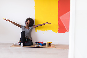 Image showing back female painter sitting on floor