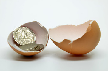 Image showing Cracked egg shell and coins