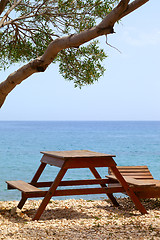 Image showing Wooden table and deck chair on summer resort at sun day