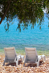 Image showing Two deck chairs on beach in sun day