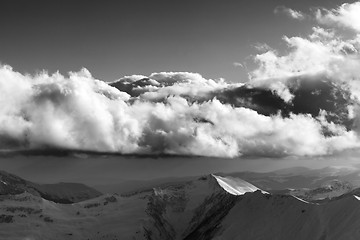 Image showing Black and white winter mountains in evening and sunlight clouds