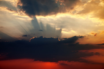 Image showing Sunset sky with dark clouds and sun rays