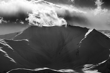 Image showing Black and white mountains in sunset with sunlit clouds
