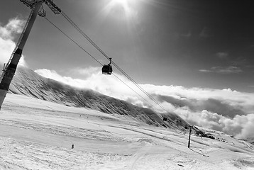 Image showing Black and white view on gondola lift and ski slope at nice sunny