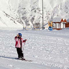 Image showing Little skier at ski resort in sun winter day