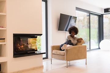 Image showing black woman in front of fireplace