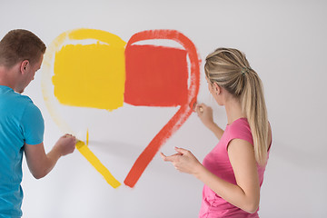 Image showing couple are painting a heart on the wall