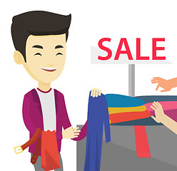 Image showing Young man choosing clothes in shop on sale.