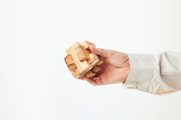 Image showing Man\'s hands holding wooden puzzle.