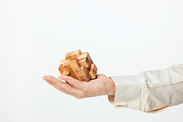 Image showing Man\'s hands holding wooden puzzle.