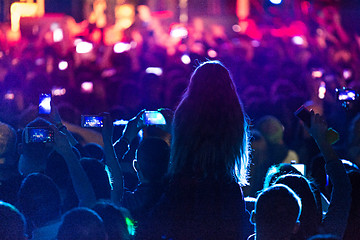 Image showing The silhouettes of concert crowd in front of bright stage lights