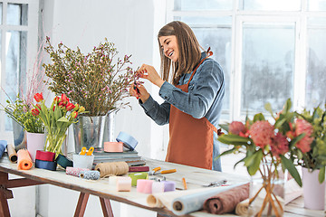 Image showing Florist at work: the young girl making fashion modern bouquet of different flowers