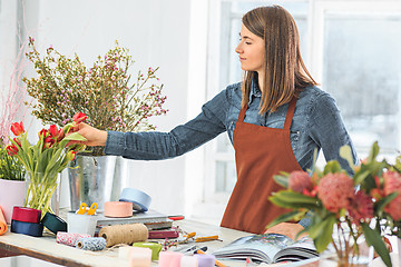 Image showing Florist at work: the young girl making fashion modern bouquet of different flowers