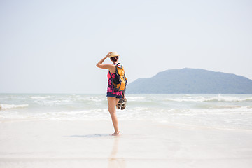 Image showing Brunette with sandals in hands