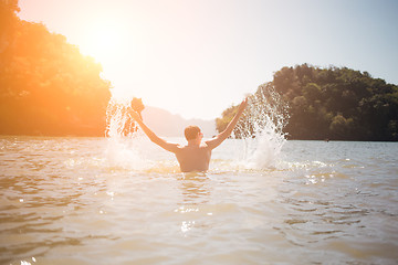 Image showing Man arms raised in sea